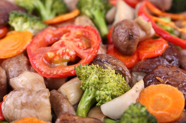 Braised wild mushrooms with vegetables and spices closeup background