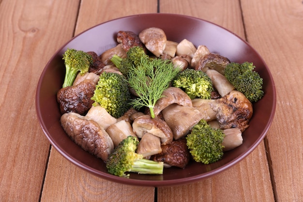 Тушеные лесные грибы с овощами и специями в тарелке на столе
