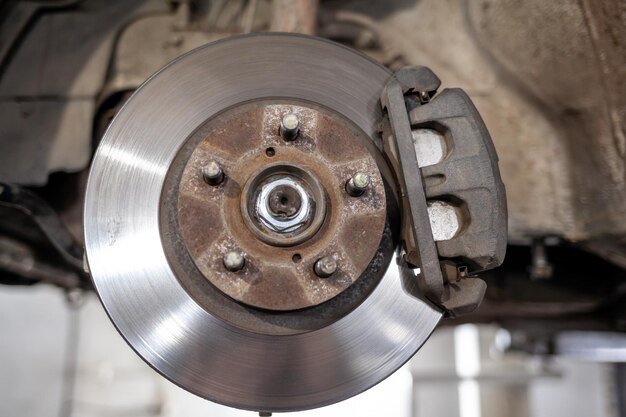 A brake disc is shown under a vehicle Disc brake of the vehicle for repair