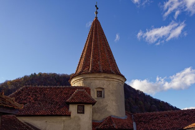 Bran Dracula Castle red tiled rooftop against blue sky in Romania Transylvania