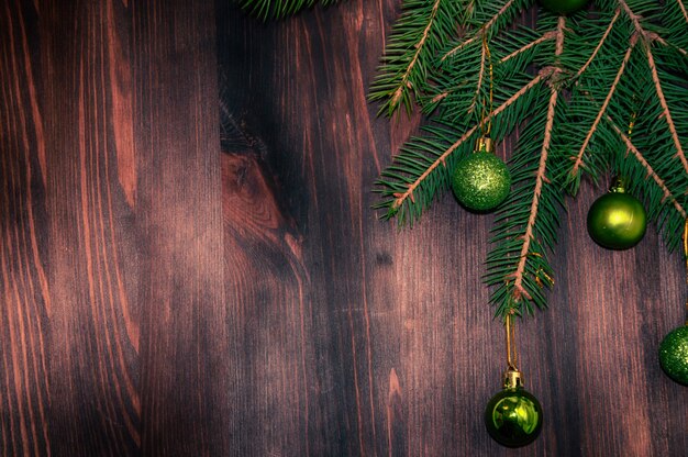 Branch ate with New Year's balls on a brown wooden background