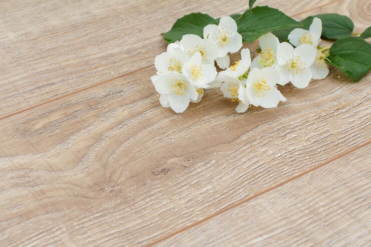 コピースペースが付いている木の板のジャスミンの花の枝休日に贈り物を与えるという概念