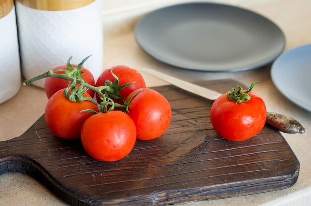 사진 잘 익은 신선한 토마토와 나무 커팅 보드에 얇게 썬 토마토의 가지 요리 재료