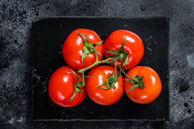 Branch of Red cherry tomatoes on marble board