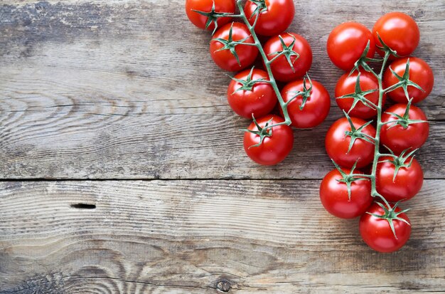 Branch of ripe cherry tomatoes on a wooden table