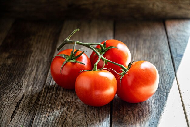 A branch of ripe tomatoes on a cutting board in the kitchen