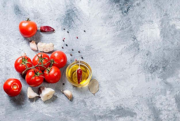 Branch tomatoes and herbs on grey background