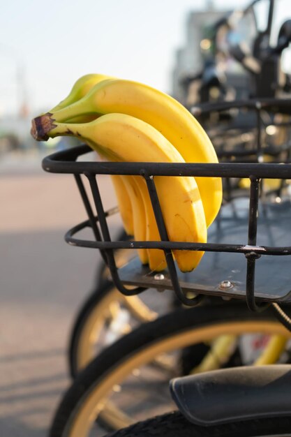 Foto un ramo di banane gialle mature in un cesto da bicicletta porta frutta