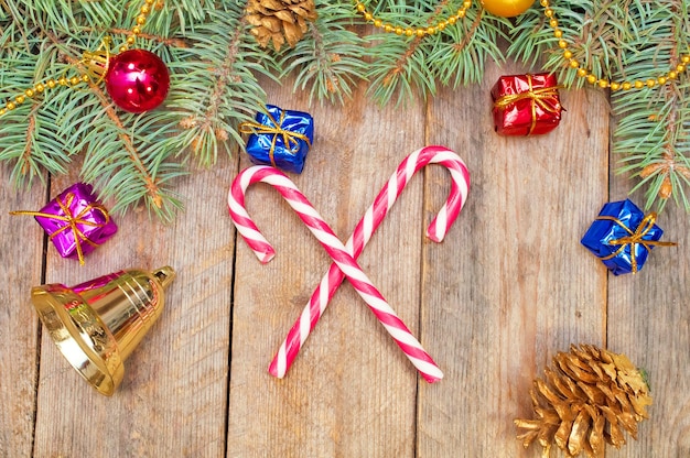 Branches of a Christmas tree with ornaments and candy on the boards