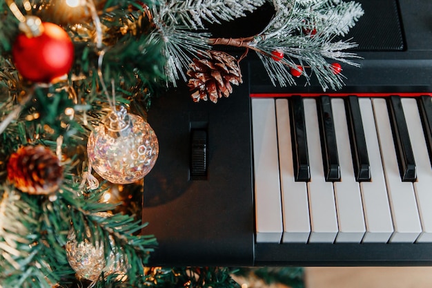 ピアノの鍵盤の背景に飾られたクリスマス ツリーの枝