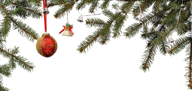 Photo branches of fir tree with ball, bells and other christmas ornament on white isolated background