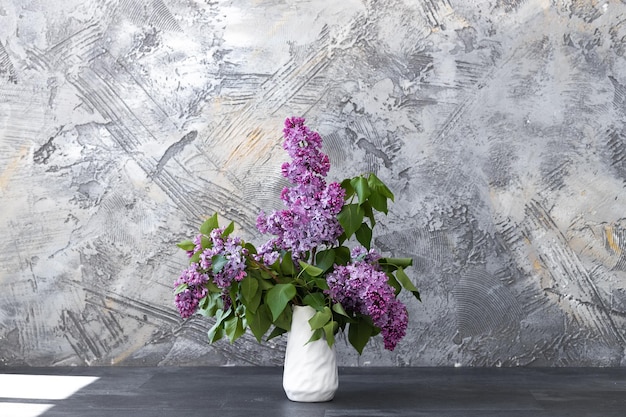 Branches of fresh purple lilac in white vase