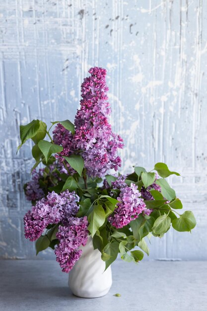 Branches of fresh purple lilac in white vase