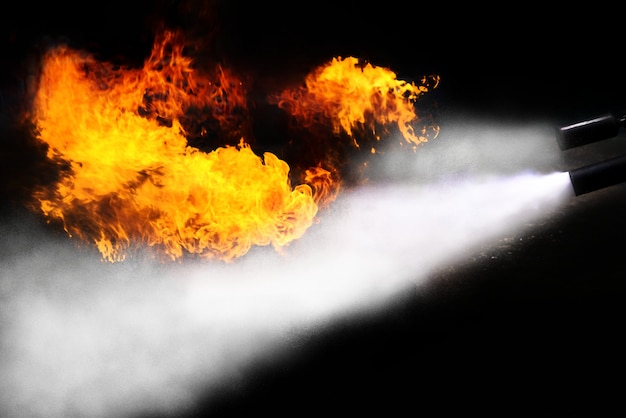 Brandblusser spray vechten hittevlam op zwarte achtergrond.