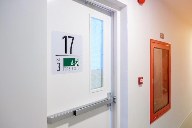 Brandblussysteem aan de muur met Fire Exit-deurbord voor noodgevallen Trappenhuisbrand voor ontsnapping in gebouw of appartement