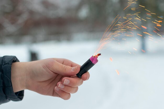 Brandend vuurwerk in een hand vonken en rook van petard