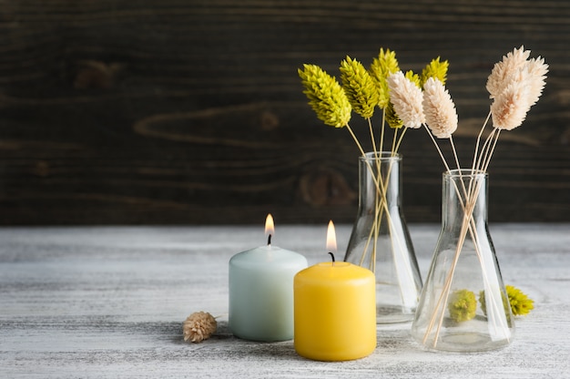 Brandende kaarsen en droge bloemen