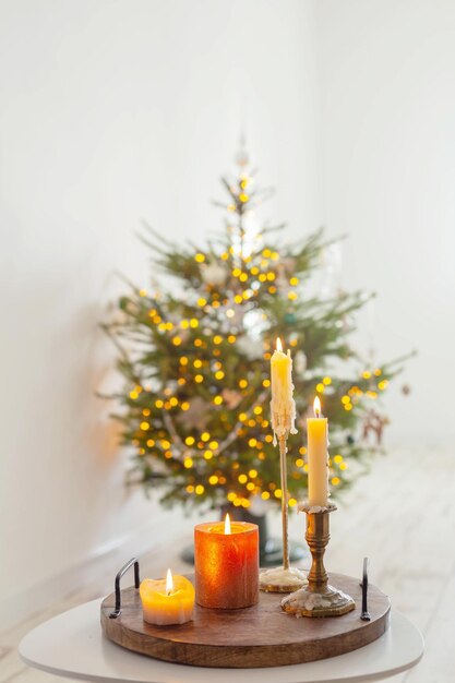 Brandende kaarsen op tafel op de achtergrond kerstboom thuis