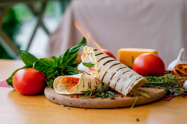 Brandende shoarma sandwich vers broodje lavash pitabroodje kip rundvlees falafel met rode tomaten en kaas met vlammen traditionele midden-oosterse snack met vlammen