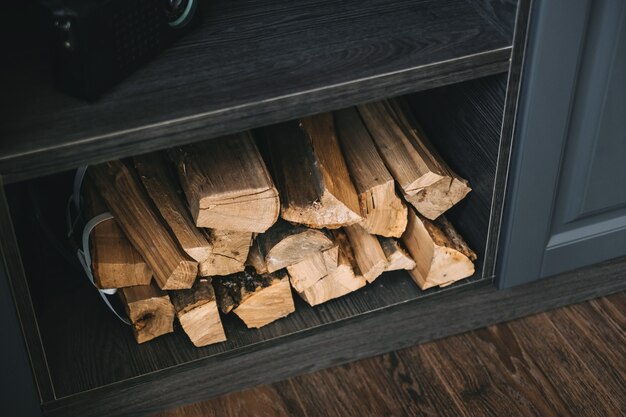 Brandhout voor een open haard op een houten plank in de keuken, close-up.