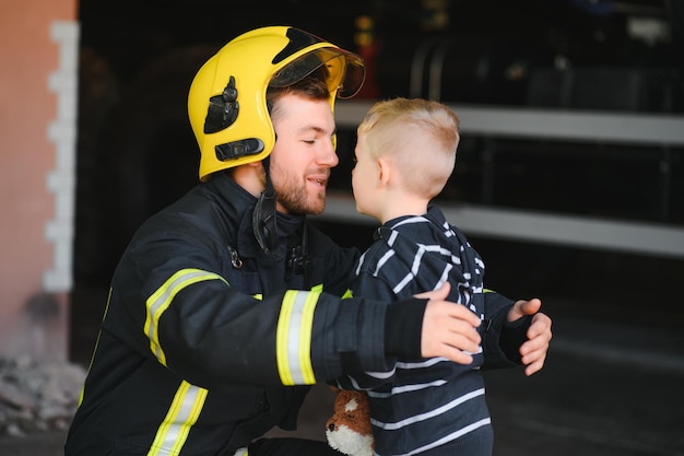 Brandweerman houdt jongetje vast om hem te redden in vuur en rookBrandweermannen redden de jongens uit vuur