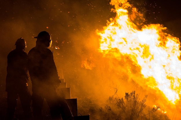 Foto brandweermannen staan bij de brand.