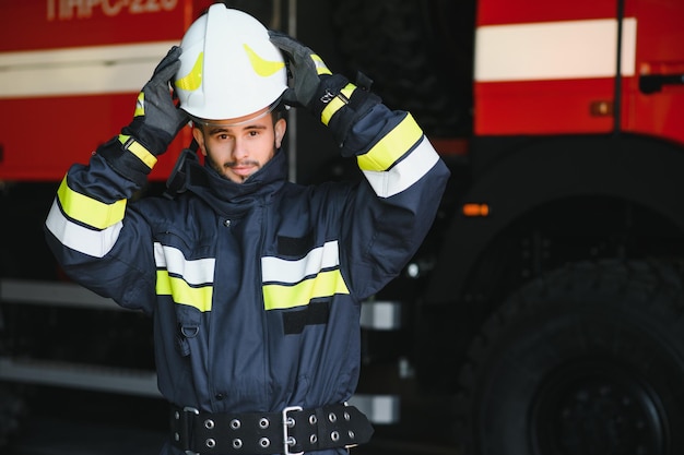 Brandweerportret van dienst Foto brandweerman met gasmasker en helm bij brandweerwagen