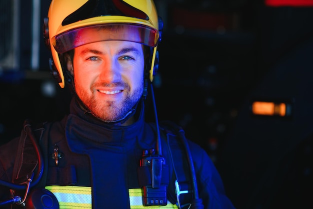 Brandweerportret van dienst Foto brandweerman met gasmasker en helm bij brandweerwagen