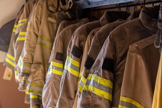 Foto brandweeruniformen en uitrusting gerangschikt bij brandweerkazerne