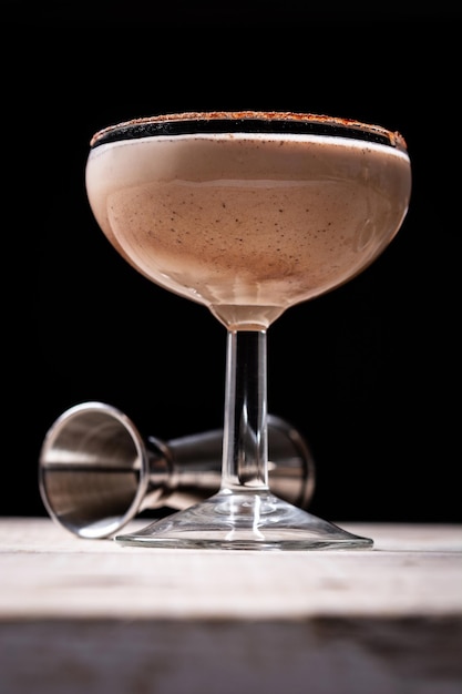 Brandy alexander cocktail on wooden table and black background