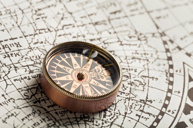 Brass antique compass on old brown map