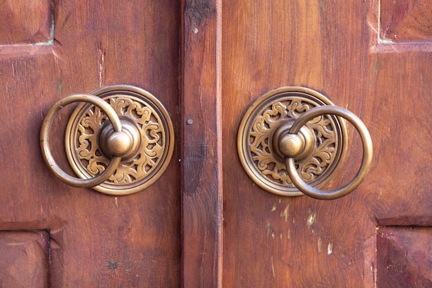 Photo brass door handles on an old wooden door