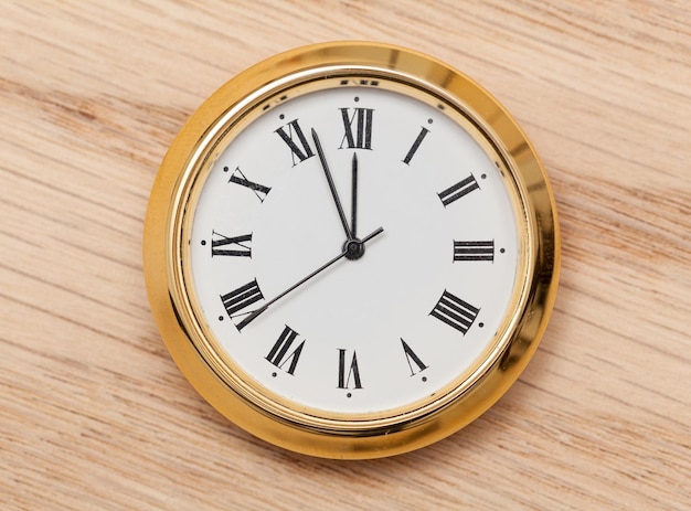 Brass small watch or clock on wood table