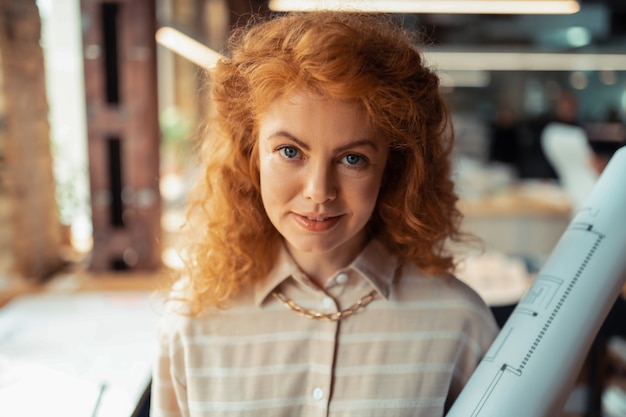 brassy curly hair. appealing blue-eyed woman with brassy curly hair wearing stylish necklace