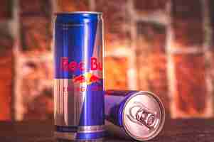 Photo bratislava slovakia 2032020 a can tin of fresh red bull drink with brick wall backround red bull company is the most popular brand in the world