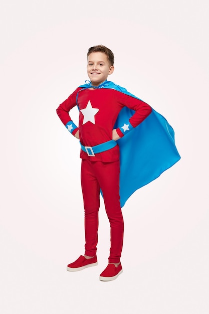 Brave boy in superhero costume in studio