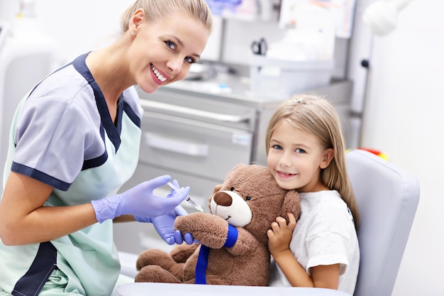 Photo brave little girl having blood collection for tests