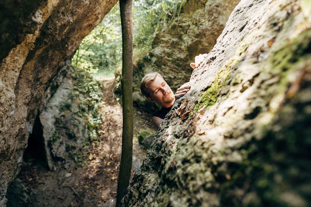 Brave young man climbs the cliff 