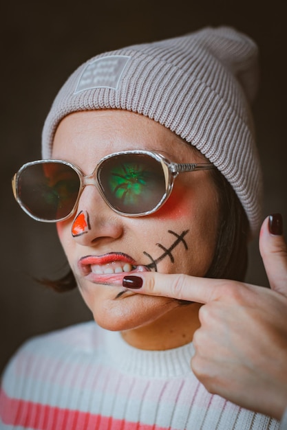 Brazen verschrikkelijke halloween hipster make-up met bril en hoed geschilderd mond litteken moderne mode