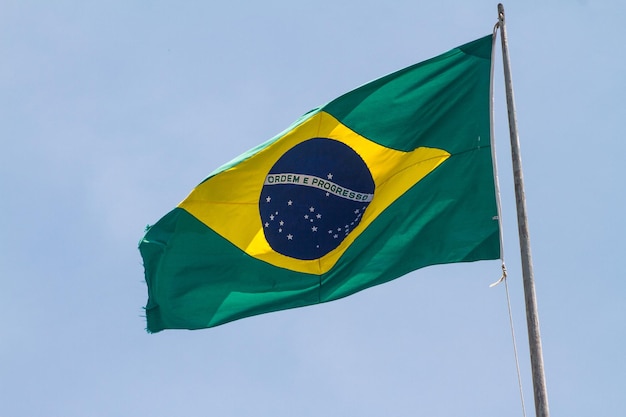 Bandiera del brasile all'aperto con un bel cielo azzurro sullo sfondo a rio de janeiro.