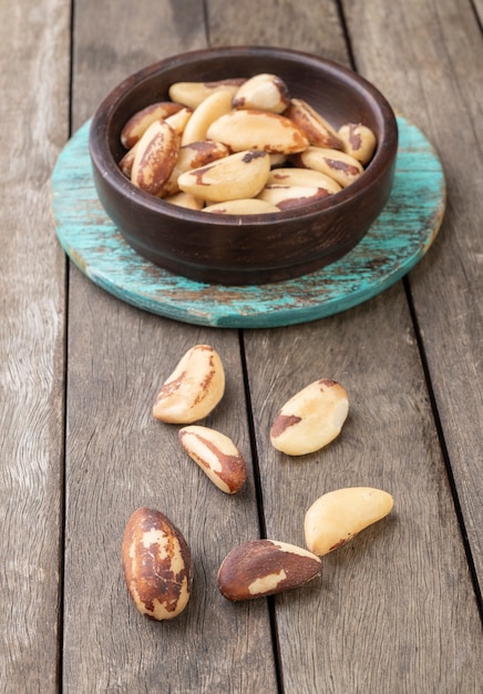 Brazil nuts on a board over wooden table.