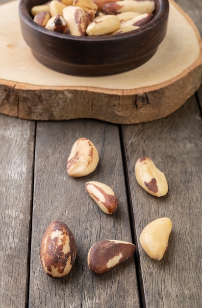 Brazil nuts on a bowl over wooden table.