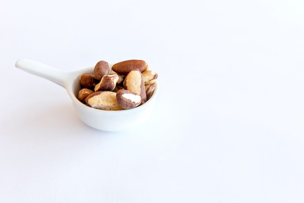 Photo brazil nuts on white background. healthy grains.