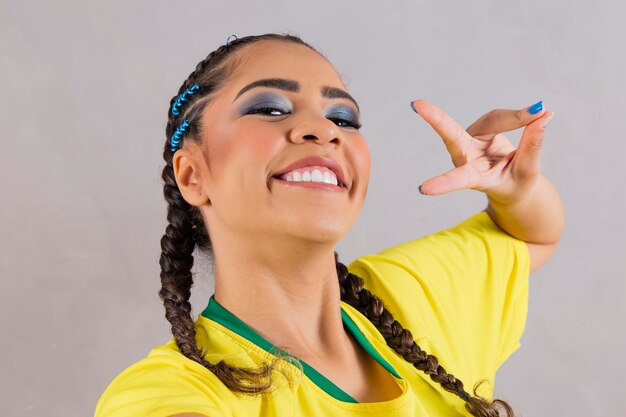 Photo brazil supporter brazilian woman fan celebrating on soccer football match on background brazil colors selfie smartphone