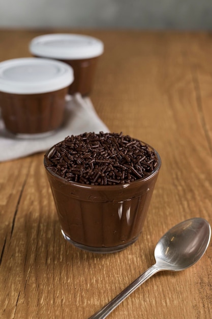 Braziliaans chocoladesnoepje genaamd Brigadeiro in pot op houten bureauachtergrond Veganistische versie