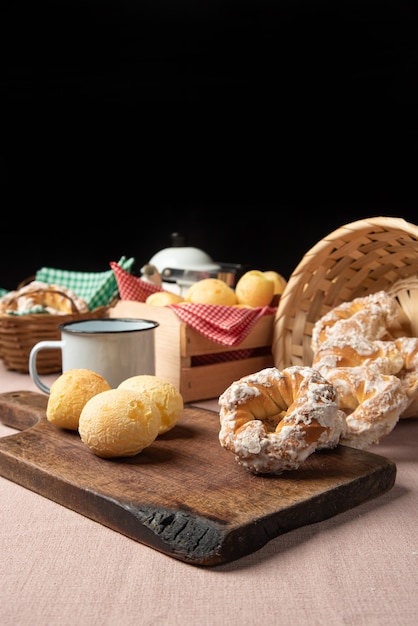 Braziliaans kaasbrood en zoet koekje en een kopje koffie op een tafel met beige tafelkleed, selectieve focus.