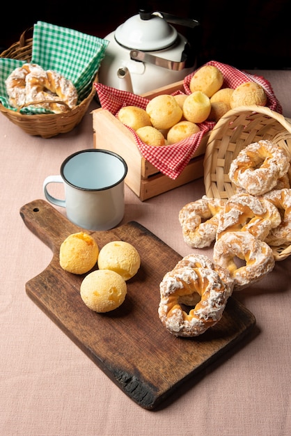 Braziliaans kaasbrood en zoet koekje en een kopje koffie op een tafel met beige tafelkleed, selectieve focus.