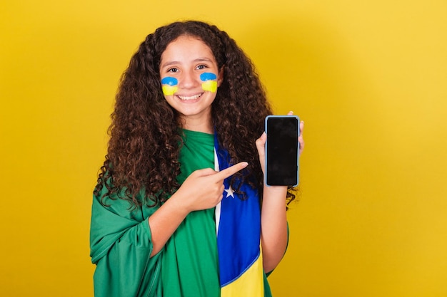 Braziliaans Kaukasisch meisje voetbalfan met mobiele telefoon met scherm mobiele telefoon app verbonden WK Olympische Spelen