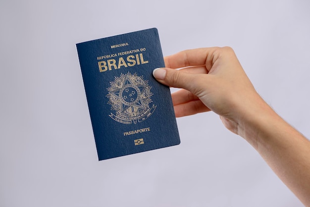 Braziliaans paspoort in een hand met witte achtergrond