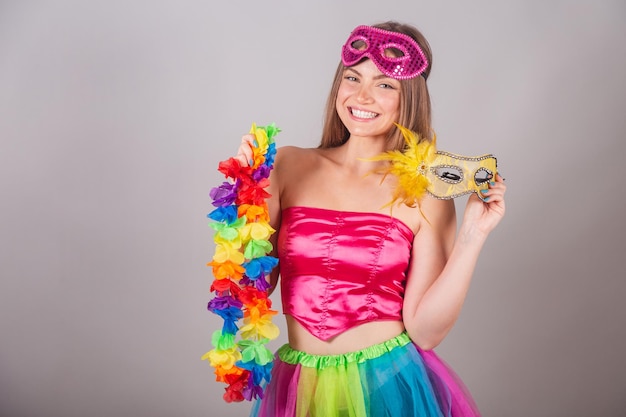 Braziliaanse blonde vrouw gekleed in roze carnavalskleren met masker en bloemenhalsband